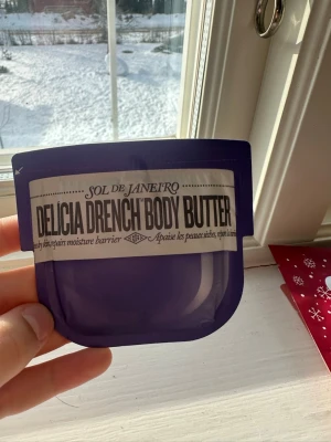Sol de Janeiro Delicia Drench Body Butter - En lyxig body butter från Sol de Janeiro i en snygg lila förpackning. Delicia Drench Body Butter återfuktar och stärker hudens fuktbarriär. Perfekt för dig som vill ha mjuk och återfuktad hud med en fräsch känsla.