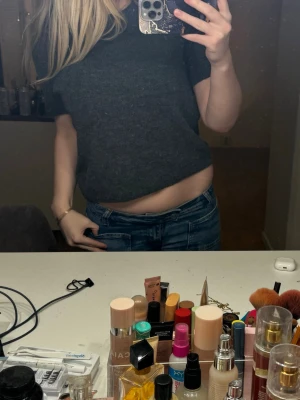 Mörkgrå  stickad topp - Mysig mörkgrå stickad tröja från H&M med rund halsringning och korta ärmar. Tröjan har en enkel, rak passform och är tillverkad i ett mjukt, ulligt material. Storlek L 