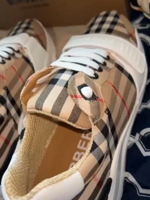 Burberry rutiga sneakers - Snygga sneakers från Burberry med det klassiska beige, svarta och röda rutmönstret. Skorna har vita snören, vita detaljer och en chunky vit sula. Materialet är textil med läderdetaljer och insidan är mjukt fodrad för extra komfort. Du får me en box o en dustbag 