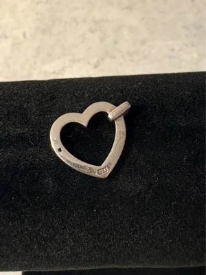 Hjärthänge i silver 925 - Säljer ett stilrent hjärthänge i äkta silver 925. Hänget har en öppen hjärtformad design och är perfekt att bära på en kedja. Enkel och tidlös look som passar till många stilar. Fint skick! 