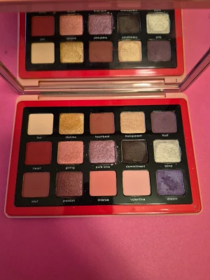 Natasha Denona Love Palette ögonskugga - Natasha Denona Love Palette med 15 ögonskuggor i olika nyanser av rosa, lila, guld, rött och neutrala toner. Paletten har både matta och skimriga färger, perfekt för kreativa och färgstarka ögonlooks. Kommer i en snygg rosa förpackning med spegel.