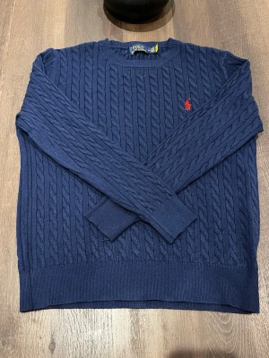 Ralph lauren tröja - Säljer en stilren och tidlös polotröja i nyskick. Aldrig använd och fortfarande helt utan prislapp.  Tillverkad i mjuk och bekväm bomull som andas bra och sitter skönt mot kroppen. Perfekt för både vardag, jobb eller en mer uppklädd casual stil.