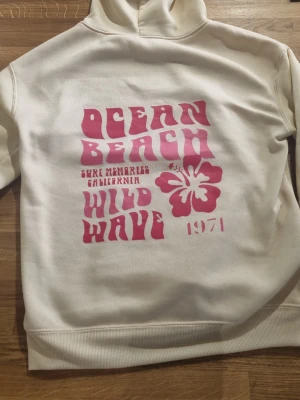 Hoodie med tryck - Snygg ljusgul hoodie med rosa tryck på fram och baksidan, perfekt för sommaren