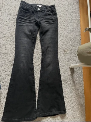 Svarta lågmidjade bootcut jeans  - Helt nyskick från Gina Tricot, säljer för att dem inte passar💞innerbenslängd 80cm, midja tvärs över ca 34cm, grenhöjd 16cm💞Alla stenar på bakfickan sitter kvar💞 Mörkare/svartare i verkligheten än på bilden💞Kom privat för mer bilder eller frågor