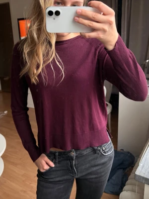 Vinröd basic tröja  - En enkel och stilren vinröd tröja med rund halsringning och långa ärmar. Tröjan har en rak passform och är tillverkad i ett tunt, mjukt material. Vinröd/lila färg  