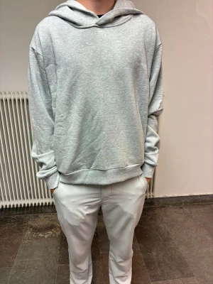 Grå hoodie från Acne Studios - Snygg grå hoodie från Acne Studios med stor huva och tryck på ryggen där det står 'Acne Studios STOCKHOLM 1996'. Oversized passform och mjukt material, perfekt för en avslappnad streetwear-look. XS men  oversize kan passa S och eventuellt M.