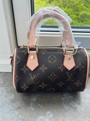 En snygg liten väska helt ny i orginalförpackning  - Snygg handväska  helt ny och band ingår liten väska 
