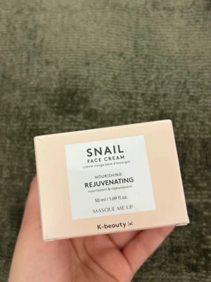 Snail Face Cream från K-beauty - Snail Face Cream från K-beauty är en närande och föryngrande ansiktskräm med snigelextrakt. Kommer i en ljusrosa burk med vitt lock, 50 ml. Perfekt för dig som vill ha återfuktad och fräsch hud. Masque Me Up.