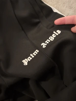 Palm Angels tracksuit - Svart tracksuit från palm angels. Byxorna är köpta för 2500 på rea äkta såklart, tröjan fick jag av en vän han säger den är äkta, säljer för jag har bytt stil