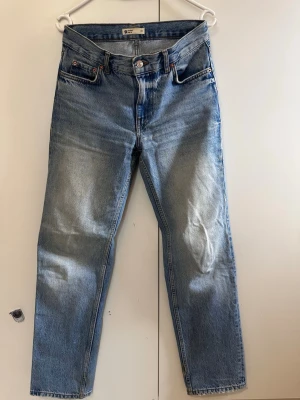 Blå raka jeans från Gina - Snygga blå jeans från Gina med rak passform och klassisk femficksdesign. Jeansen har en ljus tvätt med subtila slitningar och är tillverkade i 100% bomull. Perfekta för en avslappnad och trendig look.