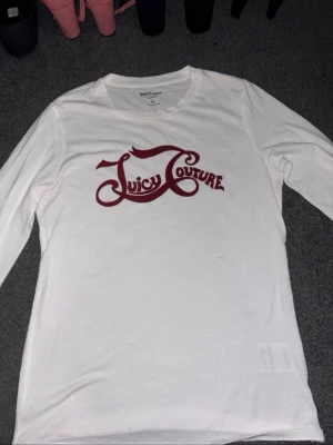 Säljer en juicy couture tröja  - Säljer en långärmad juicy couture tröja som knappt är andvänd. Där finns inga fläckar på tröjan, den e vit med vinröd text och en liten blomma på vänstra armen. Storlek xs