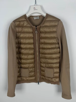 Moncler cardigan  - Moncler cardigan dam Begie. Storlek Xs. Super skick finns att köpa på våran hemsida, Fashionels.com