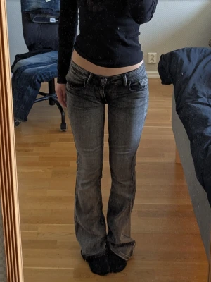 Grå bootcut jeans med låg midja - Säljer ett par grå bootcut jeans med låg midja och klassisk femficksdesign. Jeansen har en snygg tvättad look och är tillverkade i denim. Har sytt de till lågmidjat så kan ej garantera att sömmen håller därför i dåligt skick. Men pris kan diskuteras och är ganska öppen med lågt pris.
