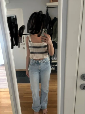 Ljusblå raka jeans med hög midja - Säljer ett par ljusblå jeans med rak passform och hög midja. Jeansen har klassisk femficksdesign och är tillverkade i denim med en lätt tvättad look. Perfekta för en avslappnad och trendig stil. Har en liten smink fläck på vänstra benet som inte går bort men som knappt syns.