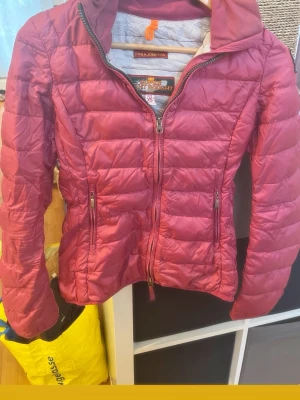 Rosa dunjacka från Parajumpers XS - Säljer en snygg rosa dunjacka från Parajumpers i modellen Super Lightweight. Jackan har dragkedja framtill, två fickor med dragkedja och quiltad design. Perfekt för kalla vinterdagar och riktigt lätt att bära.