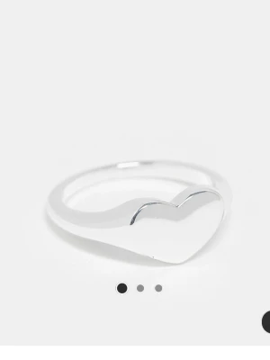 Silverpläterad ring med hjärta - Snygg silverpläterad ring med ett stilrent hjärta framtill. Ringen har en slät och blank yta som ger en modern och enkel look. Perfekt för dig som gillar minimalistiska smycken och vill ha något som sticker ut lite extra.