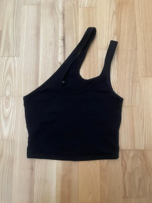 Svart oneshoulder topp - Snygg svart oneshoulder topp i stretchigt material. 