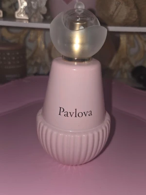 Pavlova parfym med fruktiga toner - Pavlova parfym i en ljusrosa, rundad flaska med räfflad botten och unik, frostad kork. Doften har toppnoter av jordgubbe, äpple och kola, hjärtnot av ros samt basnoter av vispgrädde, vanilj och musk. Perfekt för dig som gillar söta och blommiga dofter.