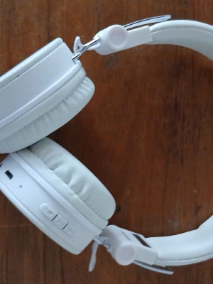 Vita trådlösa over-ear hörlurar - Snygga vita over-ear hörlurar med mjuka öronkuddar och justerbart huvudband. Hörlurarna har inbyggda knappar för volym och kontroll samt uttag för laddning och AUX. Tillverkade i plast och konstläder, perfekta för musik och gaming.