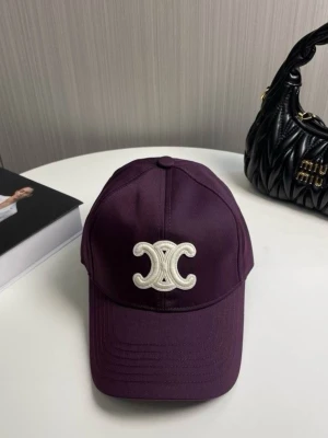 Lila keps från Celine med broderad logga - Snygg lila keps från Celine med den ikoniska broderade loggan i vitt framtill. Klassisk böjd skärm och justerbar baksida. Tillverkad i ett slitstarkt tyg som ger en cool och trendig look.