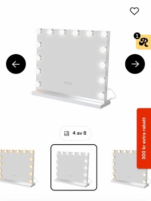 Sminkspegel med LED-belysning - Stilren sminkspegel i rektangulär form med inbyggd LED-belysning runt kanterna. Spegeln har touchknappar på framsidan och en praktisk hylla längst ner för småsaker. Färgen är vit och materialet är glas och plast/metall.