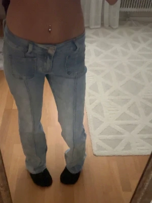 Ljusblå raka jeans med fickor - Säljer ett par ljusblå jeans med raka ben och stora fickor både fram och bak. Använda och tvättade en gång. Helt slutsålda på Madladys hemsida.