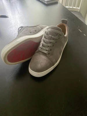 Gråa Christian Louboutin - Snygga gråa Christian Louboutin sneakers. Storlek 43. Mycket fint skick då de är använda endast 2 sommar säsonger. Ej vinter använd sedan köp! Orginala Sulor och Bag Medföljer. 3000kr eller byte mot Lanvins Toecap. PM vid frågor :)