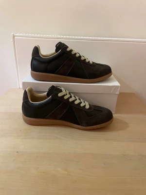 Mason Margiela Gats - Ett par helt nya Manson Margiela Gats i en svart och brun färg. Box, dustbag och visitkort ingår. Priset kan diskuteras. Skriv gärna vid frågor!  