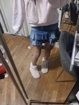 Blå volangkjol i denim xxs-xs - Säljer en blå jeanskjol med volanger och råa kanter. Kjolen är kort och har en avslappnad, trendig look som passar perfekt till en hoodie eller crop top. Materialet är klassisk denim och modellen har en loose passform.