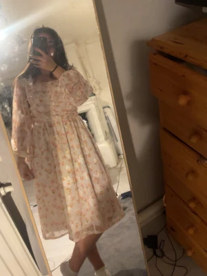 Blommig ljus klänning med volangärm - Supersöt ljus klänning med blommigt mönster och volangärmar. Klänningen har en smockad överdel, markerad midja och faller till knäna. Perfekt för vår och sommar, med romantisk och luftig känsla. Bara använts en gång, köptes från plick helt ny men lappen fanns ej med så vet inte vart den är ifrån, skulle vilja gissa på boohoo💕