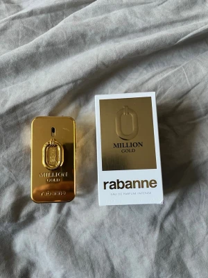 Rabanne Million Gold parfym - Rabanne Million Gold Eau de Parfum Intense i en lyxig guldig flaska med rektangulär form och metallisk finish. Parfymen kommer i originalkartong med matchande gulddetaljer. Doften är intensiv och exklusiv, perfekt för dig som gillar att sticka ut. Cirka 40-45 milliliter kvar