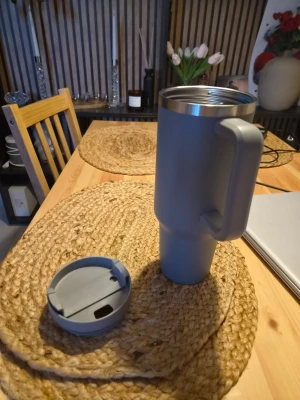 Grå vattenflaska med handtag - Säljer en stilren grå vattenflaska/termosmugg med handtag och tillhörande lock. Det ska finnas ett sugrör till men vet ej var den är