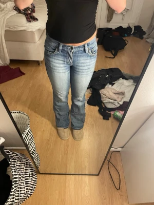 Blå bootcut jeans med nitar - Säljer ett par blå bootcut jeans med snygg slitning och coola nitar vid fickorna. Jeansen har klassisk femficksmodell och är tillverkade i stretchigt denimtyg för skön passform. Perfekta för dig som gillar en avslappnad men trendig stil. Köpta second hand vet inte strolek men passar mig som är xs-s❤️