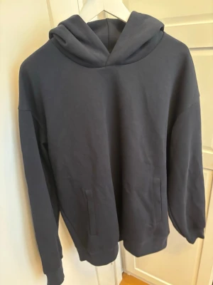 Mörkblå hoodie Uniqlo - En schysst hoodie från Uniqlo, nice passform och extremt skön. Storleken är L, den är näst in till ny,används en gång.Priset är förhandlingsbart så de är bara att buda