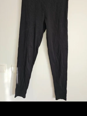 Svarta leggings med hög midja - Svarta leggings i stretchigt material med hög midja och smal passform. Perfekta att matcha med oversized tröjor eller hoodies. Klassisk modell utan synliga detaljer eller fickor. Endast testade och tvättade.