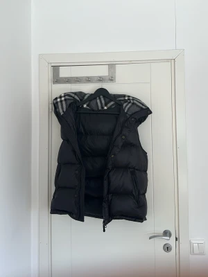 Svart dunväst burberry - Snygg svart dunväst burberry kolla sista bilden den är släppt men inget som påverkar västen negativt!