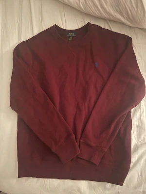 Vinröd sweatshirt från Polo Ralph Lauren - Säljer en vinröd sweatshirt från Polo Ralph Lauren med rund halsringning och blå broderad logga på bröstet. 