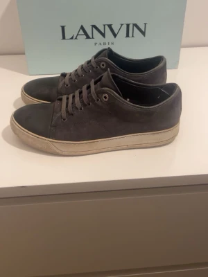 Grå sneakers från Lanvin - Skorna är strl 41.5 ,en sitter som 43. Dom är väl använda men funkar fortfarande. Skorna tvättas innan köp!