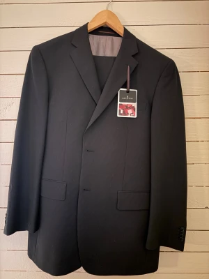 Oanvänd kritstrecksrandig kostym  - Oanvänd kritstrecksrandig kostym från dressman, storlek 52. Prislappen sitter kvar. 