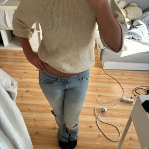 Beige stickad tröja med trekvartsärm - Säljer en beige stickad tröja med trekvartsärmar och rund hals. Tröjan har en loose passform och är perfekt för dig som gillar en enkel och stilren look. Supermjuk och lätt att matcha med jeans eller kjol. Strl S, lite nopprig osv 