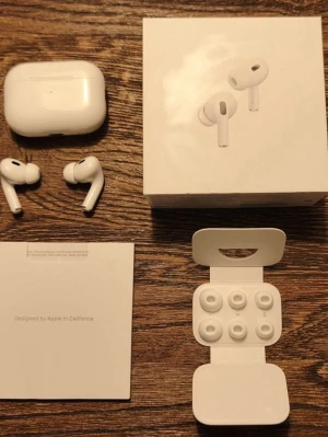 AirPods Pro - Apple AirPods Pro trådlösa hörlurar med aktiv brusreducering. Komplett med originalförpackning, laddningsetui, extra öronkuddar och manual. Hörlurarna och tillbehören ser ut att vara i mycket gott skick utan synliga skador eller slitage.