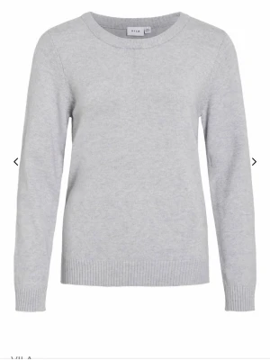 Ljusgrå stickad tröja från Vila - En enkel och stilren ljusgrå stickad tröja från Vila. Tröjan har rund halsringning, långa ärmar och ribbade muddar vid ärmslut och nederkant. Perfekt basplagg i mjukt material som passar till allt. Köparen står för frakten