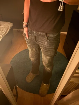  slitna jeans med raka ben - Säljer ett par jeans med slitningar och tvättade detaljer. Jeansen har raka ben, klassisk femficksmodell och normal midja. Perfekta för en avslappnad och trendig look. Storleken är 29/32 