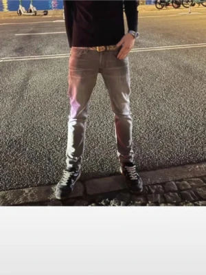 Gråa slim fit jeans från Replay - Säljer ett par gråa slim fit jeans från Replay med klassisk femficksdesign och diskret logga på bakfickan. Jeansen har en snygg tvättad look och är tillverkade i mjukt denimtyg som ger en skön passform. Perfekta till sneakers och hoodie.