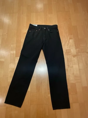 Svarta relaxed fit jeans från H&M - Säljer ett par svarta jeans från H&M i relaxed fit-modell. Jeansen har klassisk femficksdesign, raka ben och är tillverkade i ett mjukt denimtyg. Perfekta för en avslappnad och stilren look.