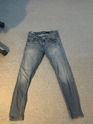 Blå slim fit jeans med schysst färg. - Snygga blå slim fit jeans från tiger of Sweden. klassisk femficksdesign. Jeansen har en smal passform och är tillverkade i denim med stretch för extra komfort. Perfekta för en avslappnad och trendig look.w 28 längd 30