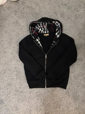 Bureberry fleece svart -  Säljer Burberry fleece med ny skick, aldrig använd och är super kvalité! Tröjan är lite mindre en storlek S skulle rekommendera tröjan till någon som har storlek XS. Om du är intresserad eller vill diskutera pris skriv privat….