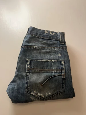 Dondup Jeans med slitningar - Säljer mina oanvända Dondup jeans med snygga slitningar. Perfekta för dig som gillar en modern och avslappnad stil.