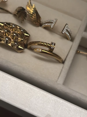 Guldfärgad ring med stenar - Snygg guldfärgad ring med öppen design och små gnistrande stenar på båda ändarna. Ringen har en modern och stilren look som passar perfekt för dig som gillar trendiga accessoarer. Helt rostfri och kommer med en dustbag. Tveka inte att fråga om fler bilder mm!💗