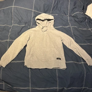 Ljusgrå hoodie från Björn Borg - Snygg ljusgrå hoodie från Björn Borg med klassisk huva och dragsko. Tillverkad i mjukt material som känns skönt mot huden. Diskret svart etikett med Björn Borg-logga framtill. Perfekt för en avslappnad och stilren look. Pris kan diskuteras vid snabb affär! 